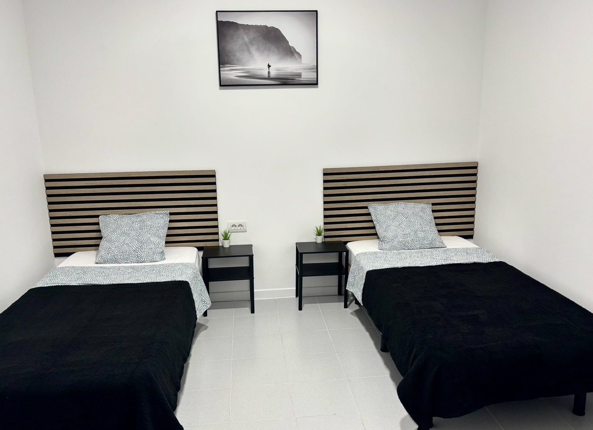 Cama en habitación compartida con baño compartido